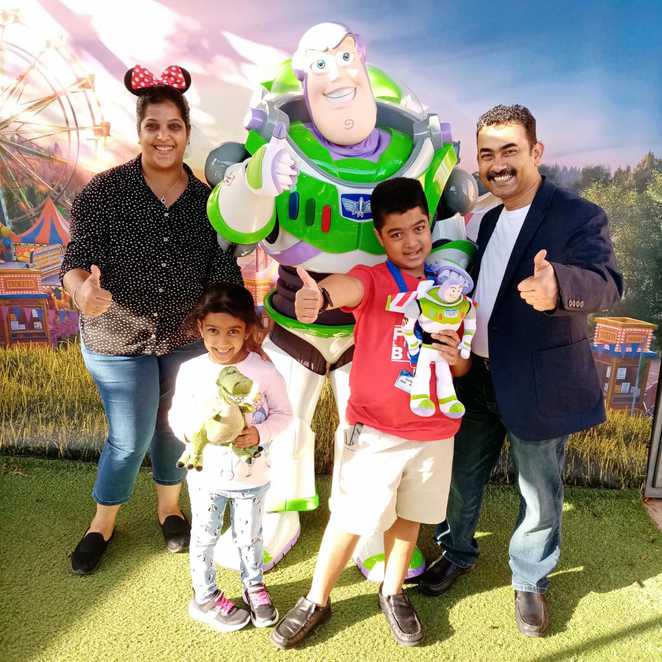 Abhi and his family giving a big thumbs up with Buzz Lightyear.
