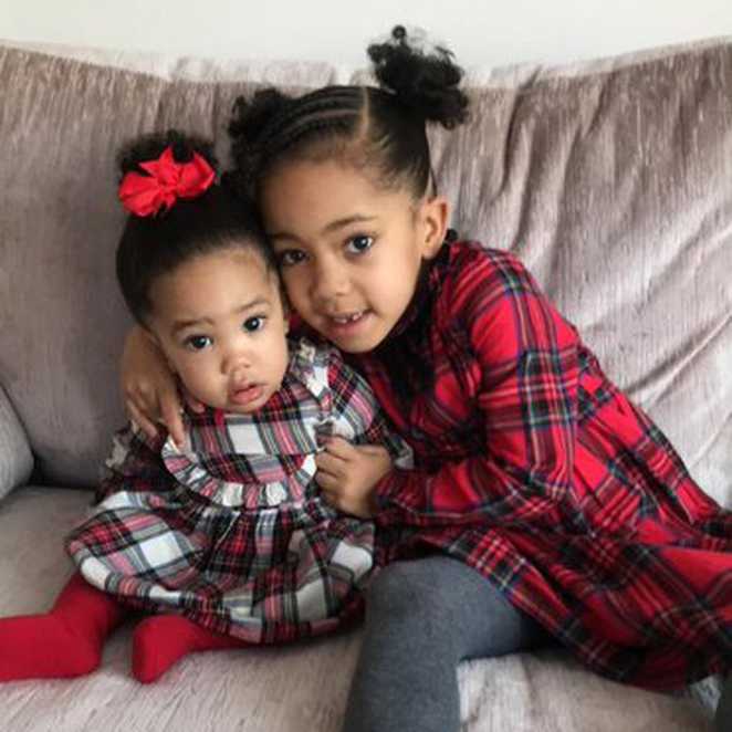 J'Anaie and her little sister Jayla wearing checked dresses.