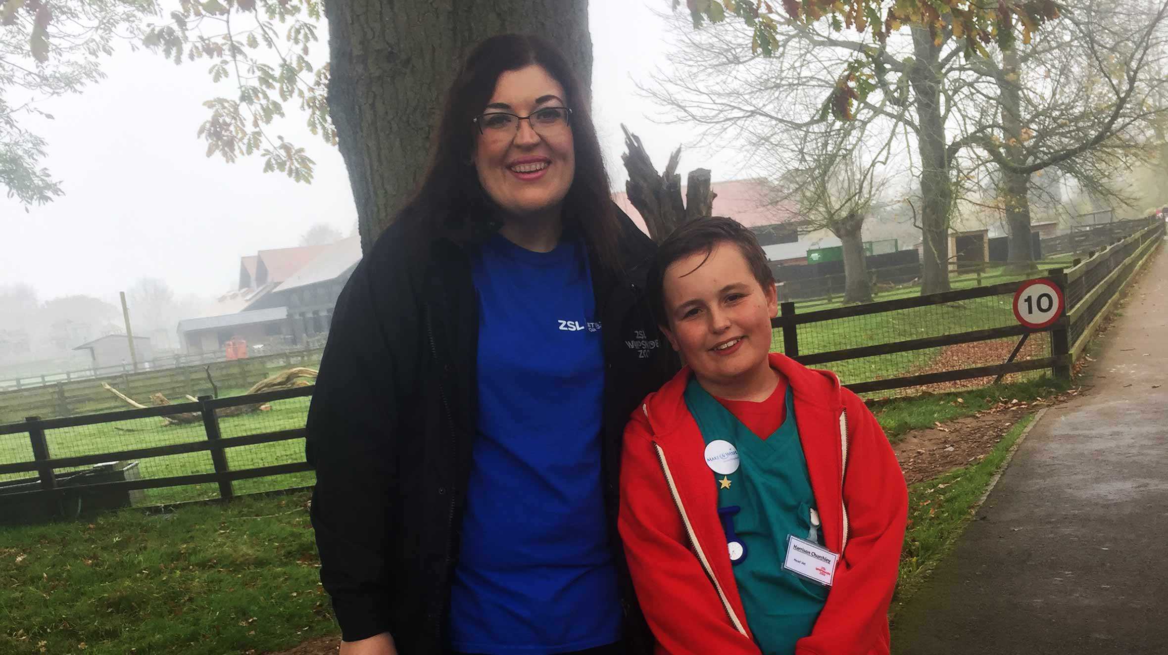 Harrison and and a member of zoo's team posing in a glade of trees at Whipsnade Zoo during his wish.