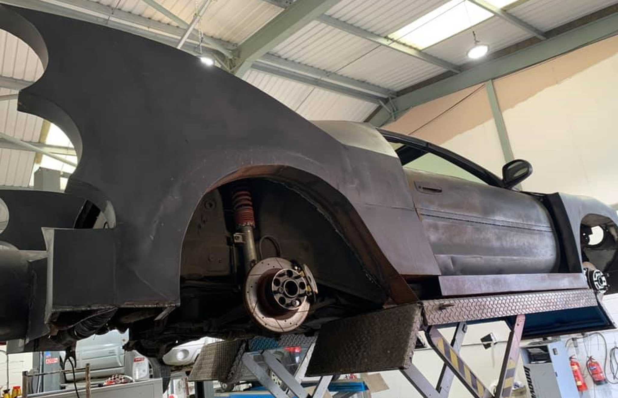 The Batmobile under construction in a garage.
